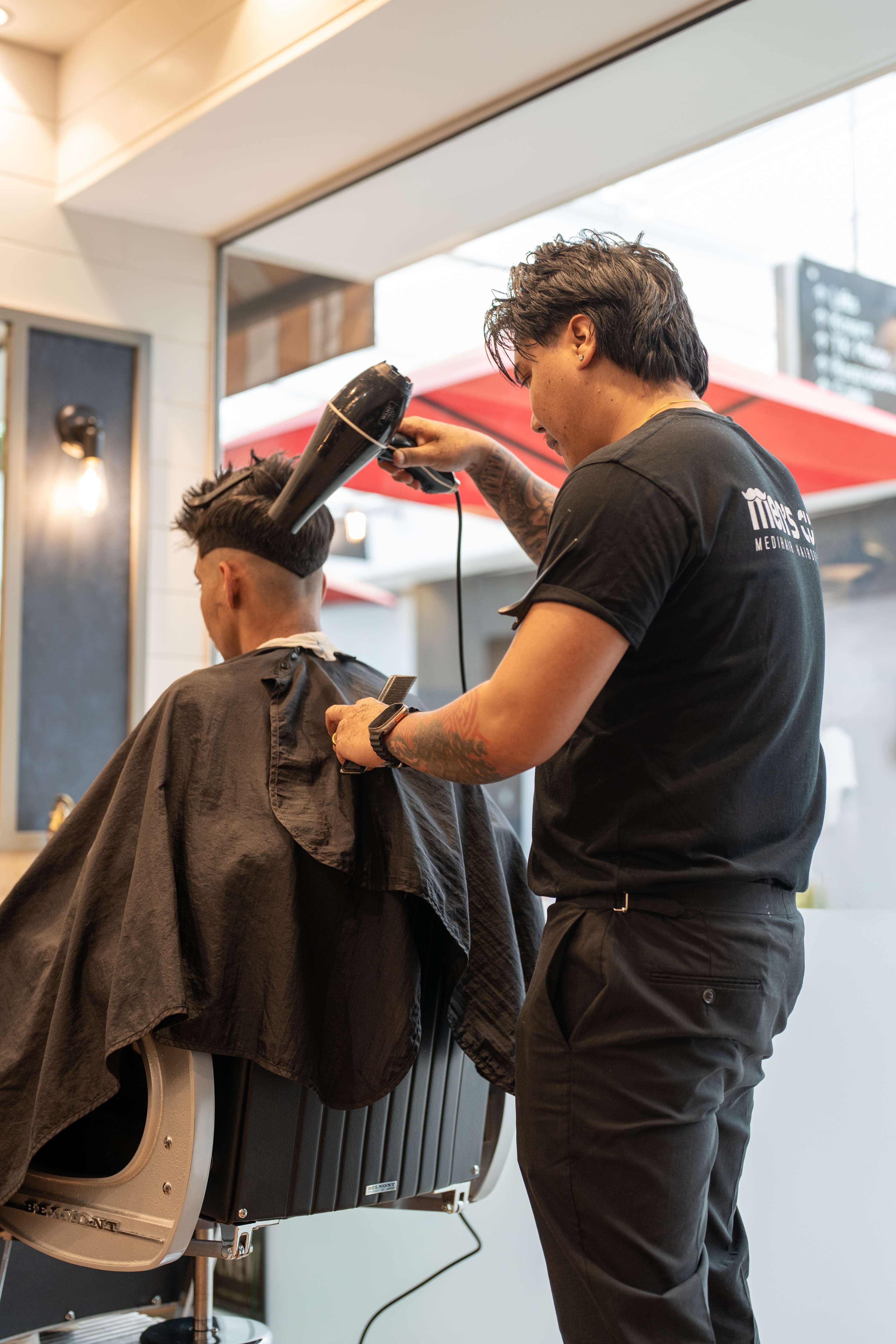 Men's Cuts barber using a hair dryer on a client